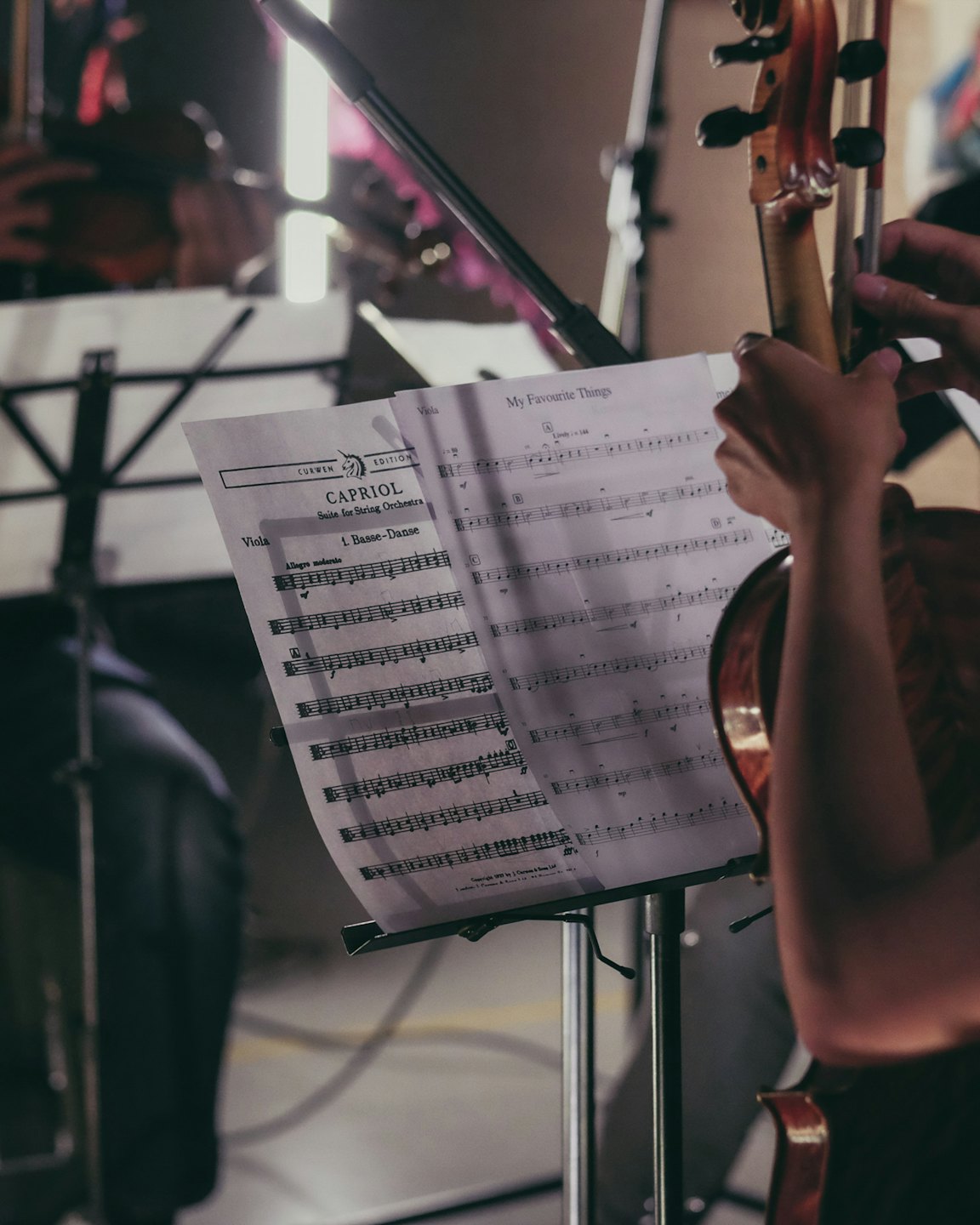 Musician plays a string instrument while reading sheet music.