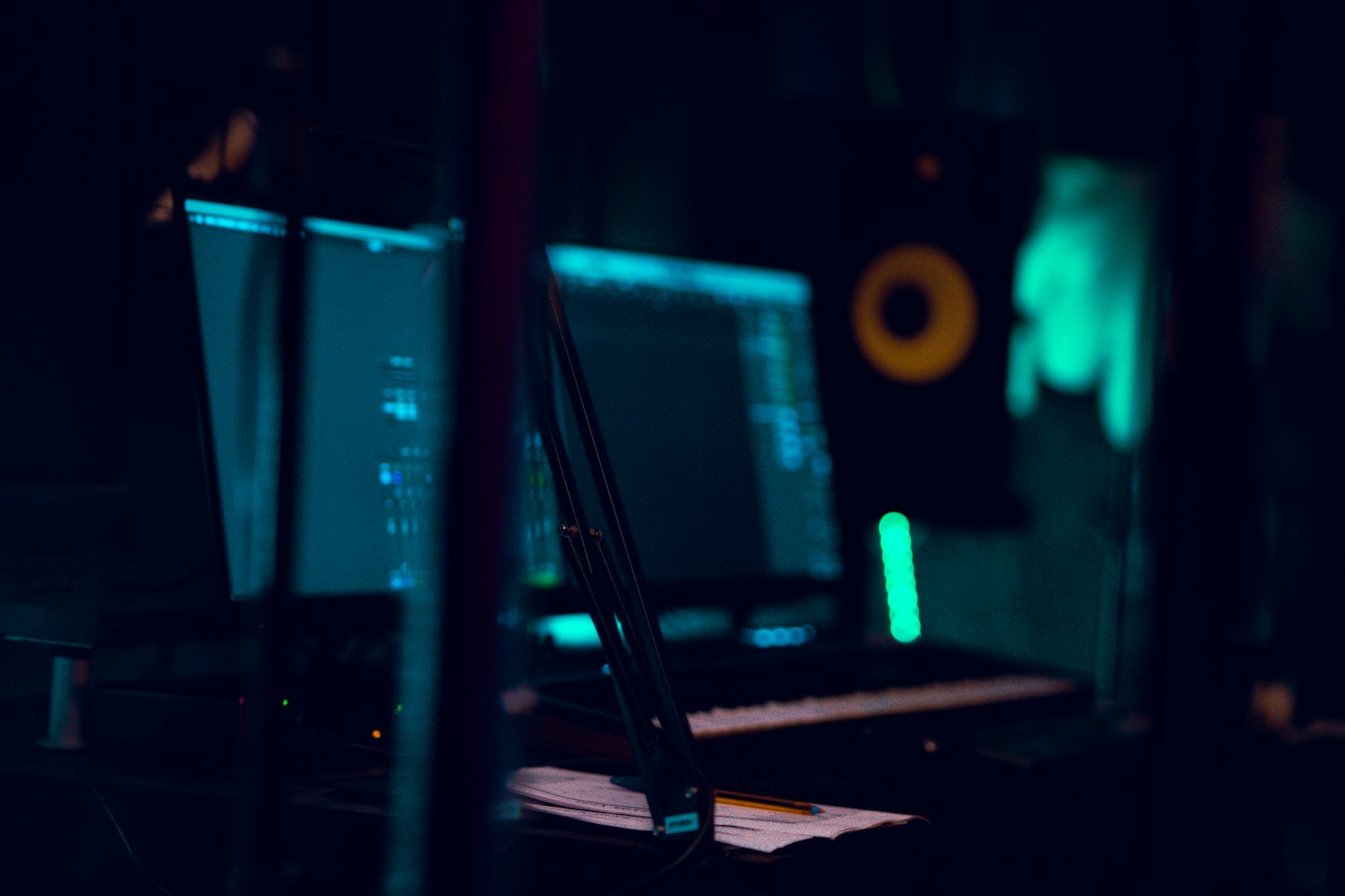 Music studio equipment with software displayed on computer monitors.